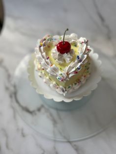 a piece of cake on a plate with a cherry on top and sprinkles around it