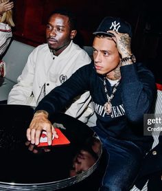 two young men sitting at a table in a club