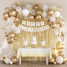 a birthday party with gold and white balloons