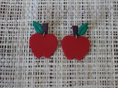 two red apple shaped earrings with green leaves