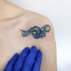 a woman's shoulder with a tattoo on it that looks like the starry night sky