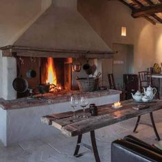 a living room filled with furniture and a fire place in the middle of an open floor plan