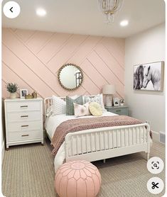 a bedroom with pink walls and white furniture