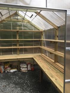 a wooden bench sitting inside of a greenhouse