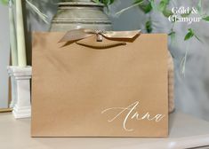 a brown paper bag sitting on top of a table next to a vase with flowers