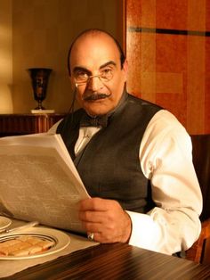 a man sitting at a table reading a book