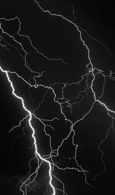 lightning strikes across the night sky in black and white