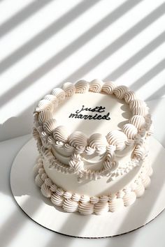 a white cake sitting on top of a table next to a shadow filled wall with the words fresh market written on it