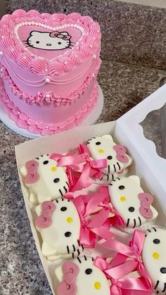 two hello kitty cakes in a box with pink bows on the side and one decorated like a heart