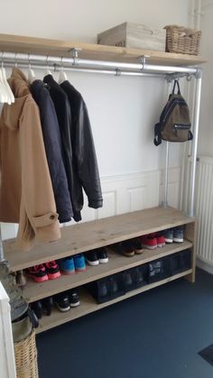 a coat rack with shoes and coats hanging on it