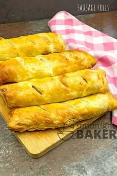 four pieces of bread sitting on top of a cutting board next to a pink and white checkered towel