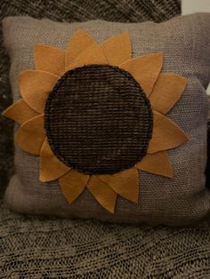 a sunflower pillow sitting on top of a couch