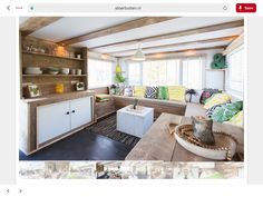 a living room filled with lots of furniture next to a wooden table and white walls