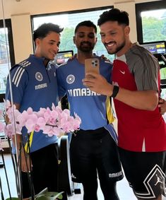 two men standing next to each other in front of a mirror taking a selfie