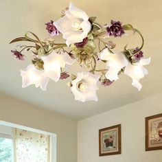 a chandelier with flowers hanging from it's ceiling in a living room