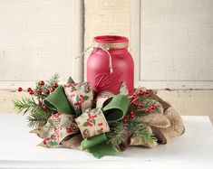 a red mason jar sitting on top of a white table next to burlocks