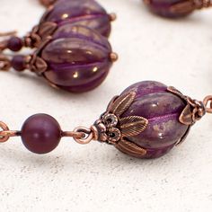 "Artisan Czech pressed glass melon beads in a translucent pinkish purple hue with a golden luster and a metallic pink wash in the recessed details. These beads are pressed in the Czech Republic in small quantities and so are of a very limited edition. The beads are capped with antiqued copper adornments and spaced with Elderberry Swarovski crystal simulated pearls. --------------------------------------------------------------------------------------------- Dimensions: - Melon beads measure 12mm Czech Beads Jewelry Bracelets, Czech Beads Jewelry, Czech Glass Bead Bracelet, Czech Glass Jewelry, Beaded Jewelry Bracelets, Pinkish Purple, Cluster Bracelets, Nature Inspired Jewelry, Metallic Pink