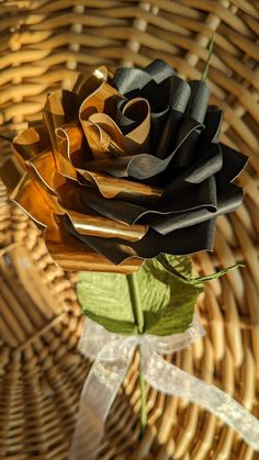 a black rose sitting on top of a wooden table next to a wicker basket