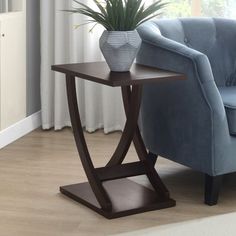 a blue chair sitting next to a table with a potted plant on it