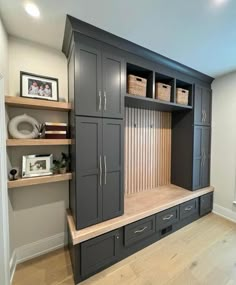 an organized mudroom with built in cabinets and baskets on the shelves, along with other items