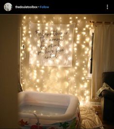 a baby's bathtub with lights on the wall and a quote above it