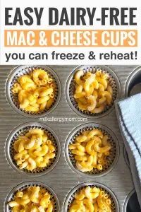 a muffin tin filled with macaroni and cheese cups next to a blue towel