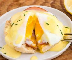 an open - faced sandwich with eggs and cheese on a white plate