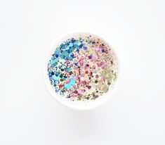 a white bowl filled with lots of different colored confetti sprinkles