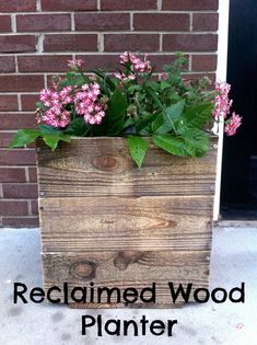 a wooden planter with pink flowers in it