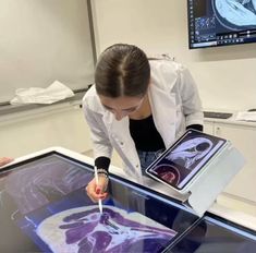 a woman is looking at an x - ray image on the table and touching it