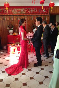 a man and woman in formal wear standing next to each other at a wedding ceremony