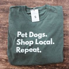 a green shirt that says pet dogs shop local repeat