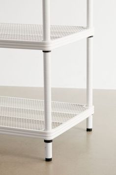 three tiered white shelving unit with black piping on the bottom and sides