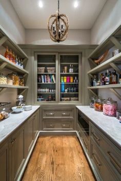 a kitchen filled with lots of counter top space next to a light hanging from the ceiling