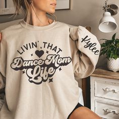 Step into the spotlight, Dance Moms! 🌟 Presenting our Personalized Dance Mom Sweatshirt, where comfort meets personalized style! 🩰💖 👚 **Classic Fit & Comfort Get ready to dance through your day in the classic fit and crew neckline of our sweatshirt. It promises a comfy wearing experience with a clean-cut style, making it the perfect companion for your bustling dance schedule. 💃🕺 🌈 **Durability & Craftsmanship We believe in quality that lasts! Our sweatshirt features double-needle stitchin Dance Nationals Shirts, Dance Moms Shirts Ideas, Dance Mom Outfits Style, Long Sleeve T-shirt With Letter Print For Dance, Long Sleeve Letter Print T-shirt For Dance, Crew Neck Sweatshirt With Letter Print For Dance, Graphic Print Crew Neck Sweatshirt For Dance, Cotton Hip Hop Sweatshirt For Dance Class, Crew Neck Graphic Print Sweatshirt For Dance