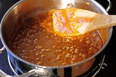 a wooden spoon stirring beans in a pot