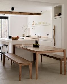 a table and bench in a white kitchen