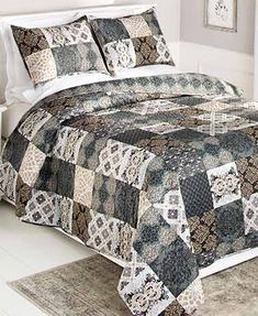 a bed covered in a black and white quilt