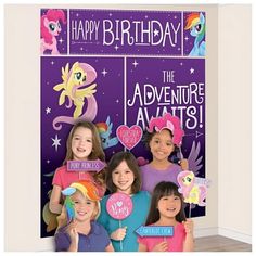 a group of girls standing next to each other in front of a purple wall with the words happy birthday on it