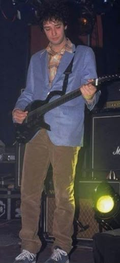 a young man playing an electric guitar on stage