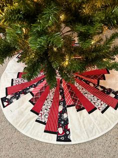 a christmas tree skirt made out of red and black ribbon