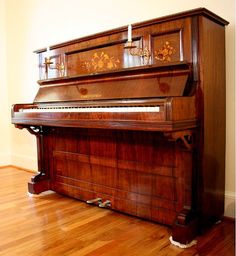 an old piano sitting on top of a hard wood floor