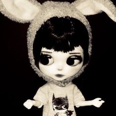 a black and white photo of a doll with bunny ears