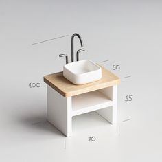 a white sink sitting on top of a wooden table next to a faucet