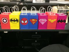 some bags with different designs on them are lined up in front of a computer desk