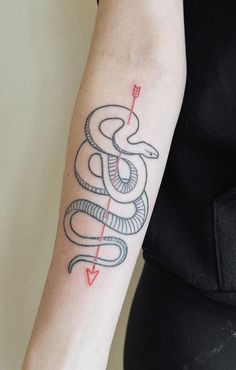 a woman's arm with a snake and arrow tattoo on the left side of her arm