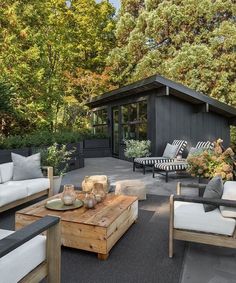 an outdoor living area with couches, tables and chairs in the middle of it