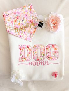 a white bag with pink flowers and the word dog mama on it next to a flower