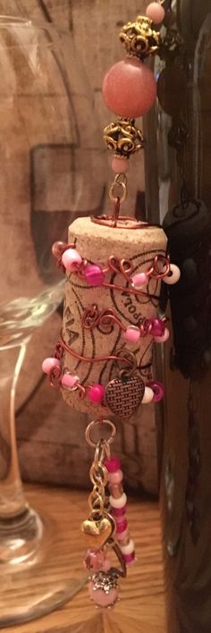 a close up of a glass vase with beads and charms on the top of it