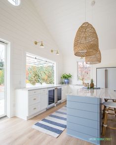 a kitchen with white cabinets and blue counter tops next to an open door that leads to a patio